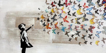 Een vrouw met lang, bruin haar staat tussen zonnige zonnebloemen en kijkt naar de horizon, terwijl ze een hoed vasthoudt.