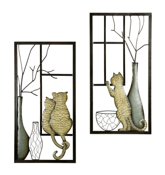 Twee wanddecoraties met katten in goudkleur en zilver, omlijst door zwarte metalen frames, gecombineerd met vazen en takken.