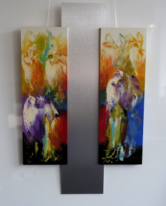 Twee abstracte schilderijen met bloemmotieven in levendige kleuren, omgeven door een glanzend metalen paneel. Twee abstracte schilderijen met bloemmotieven in levendige kleuren, omgeven door een glanzend metalen paneel.