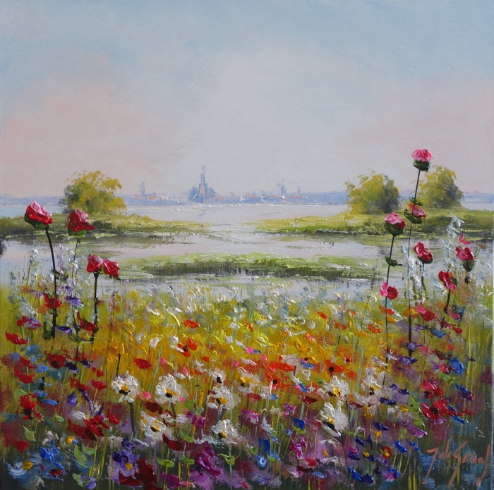 Kleurrijke bloemenweide met heldere rozen in de voorgrond, tegen een rustige waterachtergrond en een blauwe lucht.