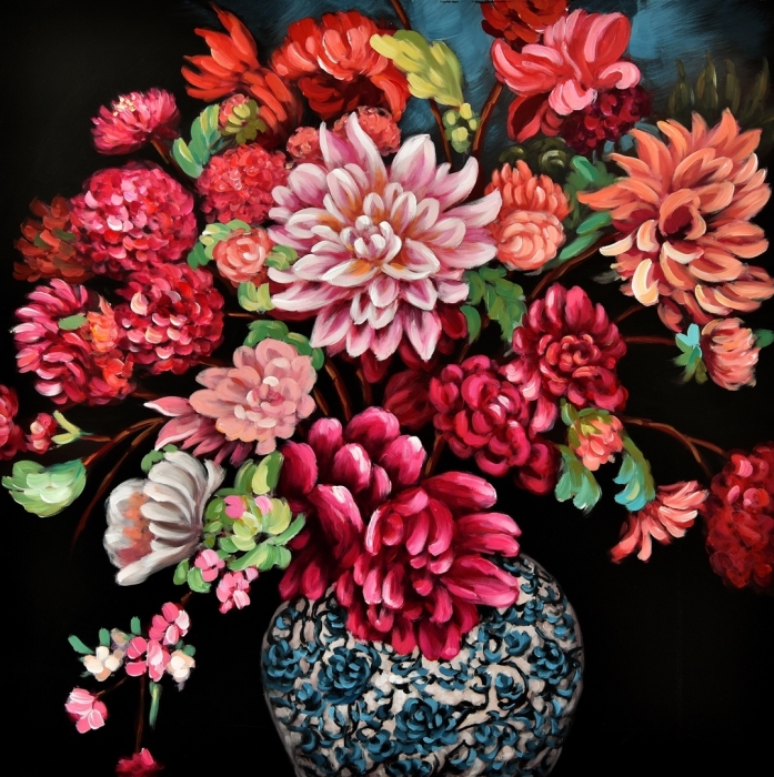 Kleurrijke boeket met volle, variërende bloemen in tinten roze en rood, geplaatst in een blauw-witte, versierde vaas.