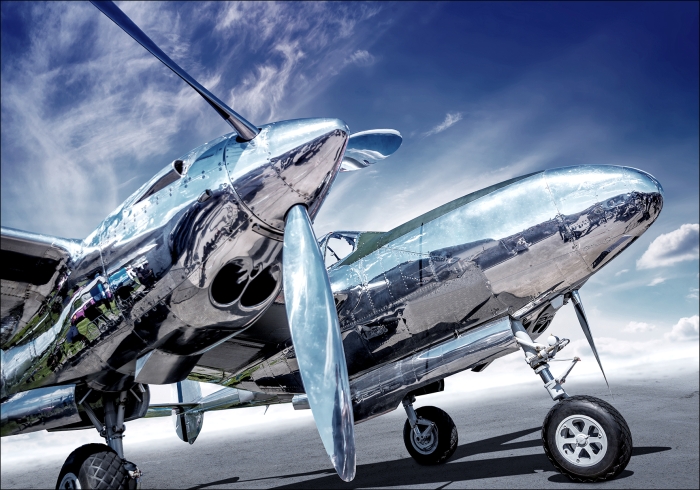Een glanzend, vintage vliegtuig met een reflecterende romp en propeller, tegen een heldere blauwe lucht en witte wolken. Een glanzend, vintage vliegtuig met een reflecterende romp en propeller, tegen een heldere blauwe lucht en witte wolken.