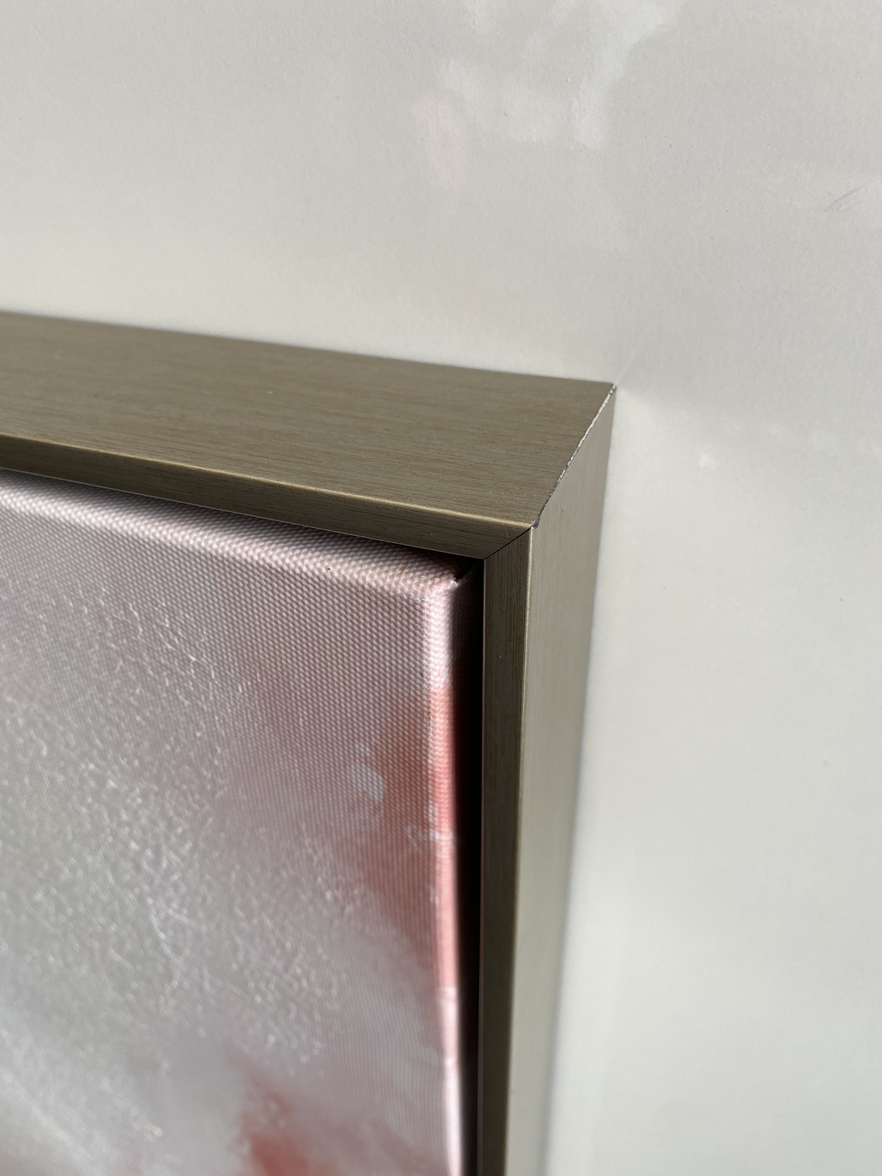 Abstracte schildering met zachte tinten van roze en wit, accentueerd door gouden vleugen en dynamische lijnen.